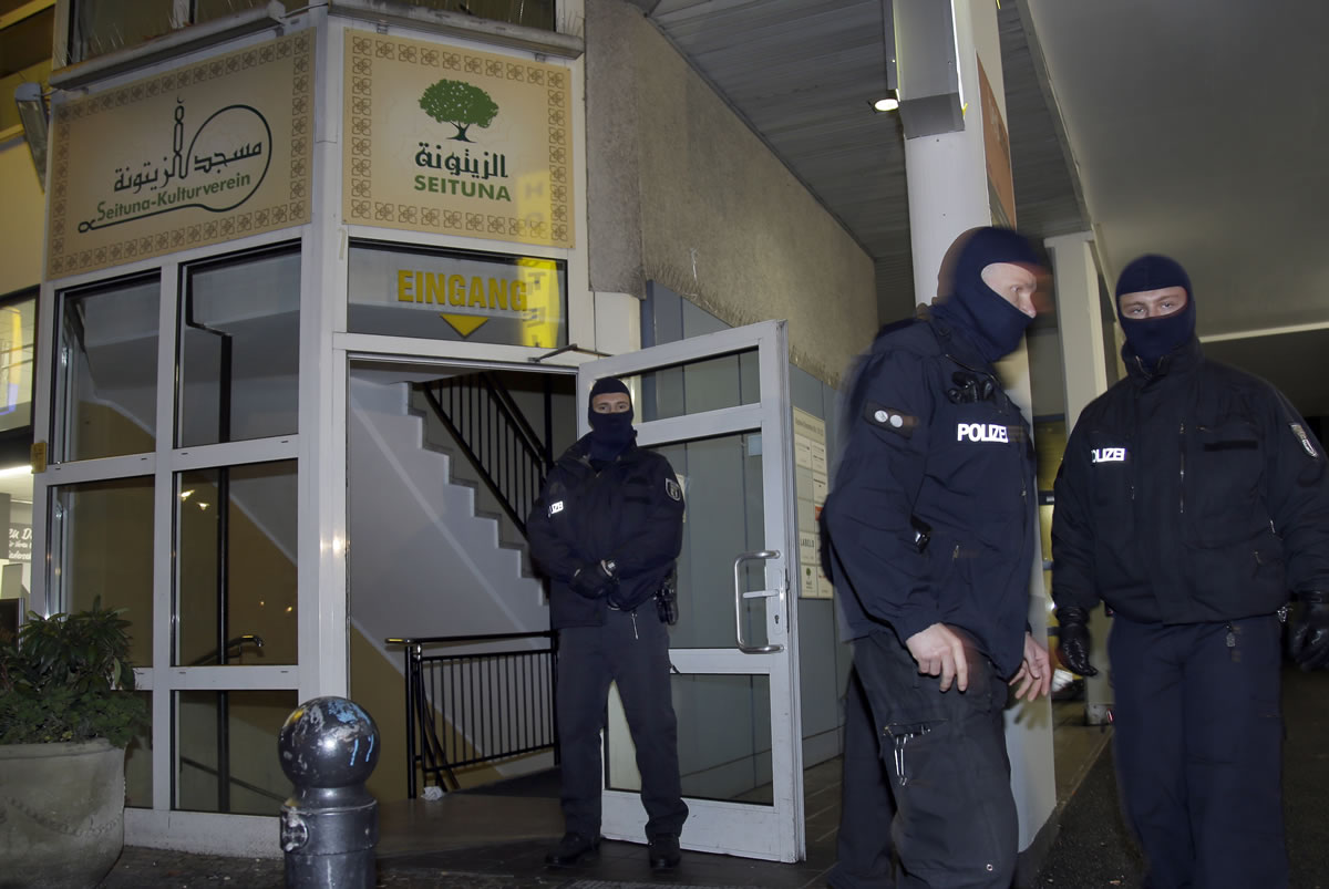 Masked police officers guard the &#039;Seituna&#039; cultural center in Berlin, Germany, on Thursday. Police raided the mosque after the arrest of two people suspected of belonging to an Islamist extremist group.
