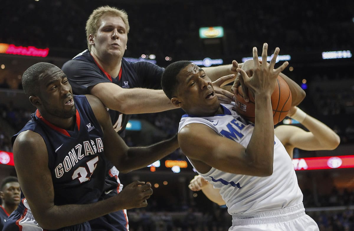 Memphis forward Nick King, right, tries to hang onto a rebound against Gonzaga center Sam Dower Jr. (35) and center Przemek Karnowski, back, in the second half Saturday. Memphis won 60-54.