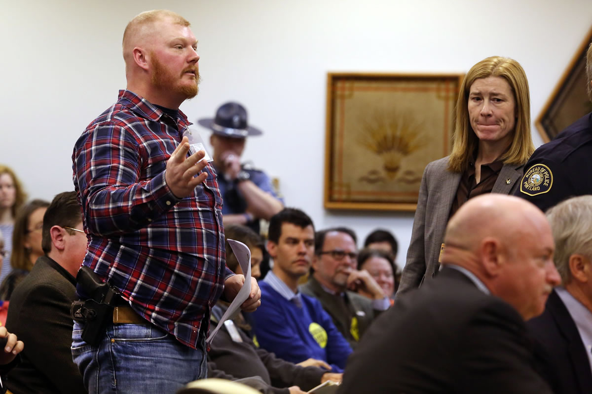 Casey Runyan, left, speaks in front of the Senate Judiciary Committee at a public gun bill hearing at the State Capitol in Salem, Ore., on Thursday.