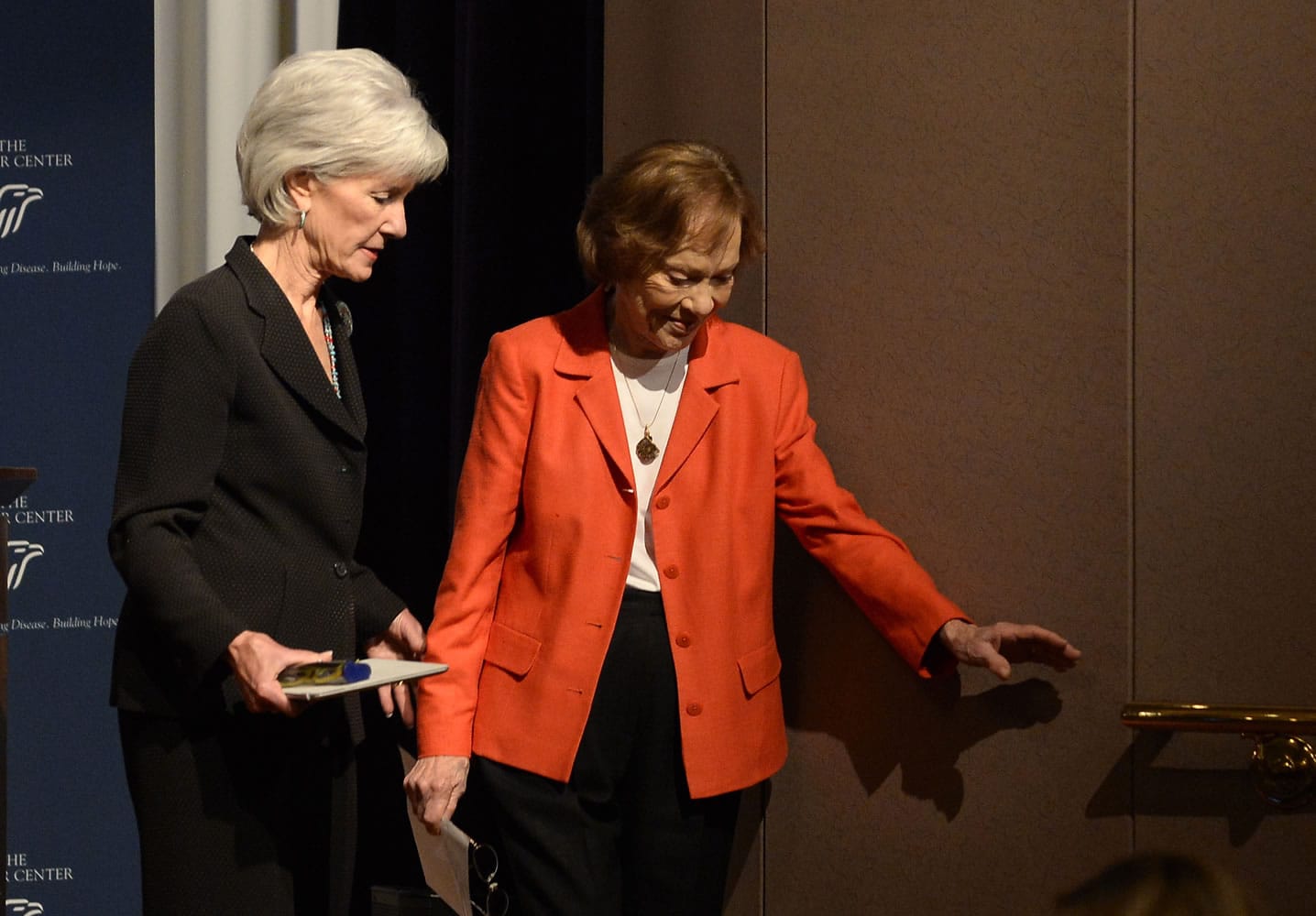 Department of Health and Human Services Secretary Kathleen Sebelius, left, helps former first lady Rosalynn Carter down the stairs at the 29th annual mental health policy symposium at the Carter Center on Friday in Atlanta.