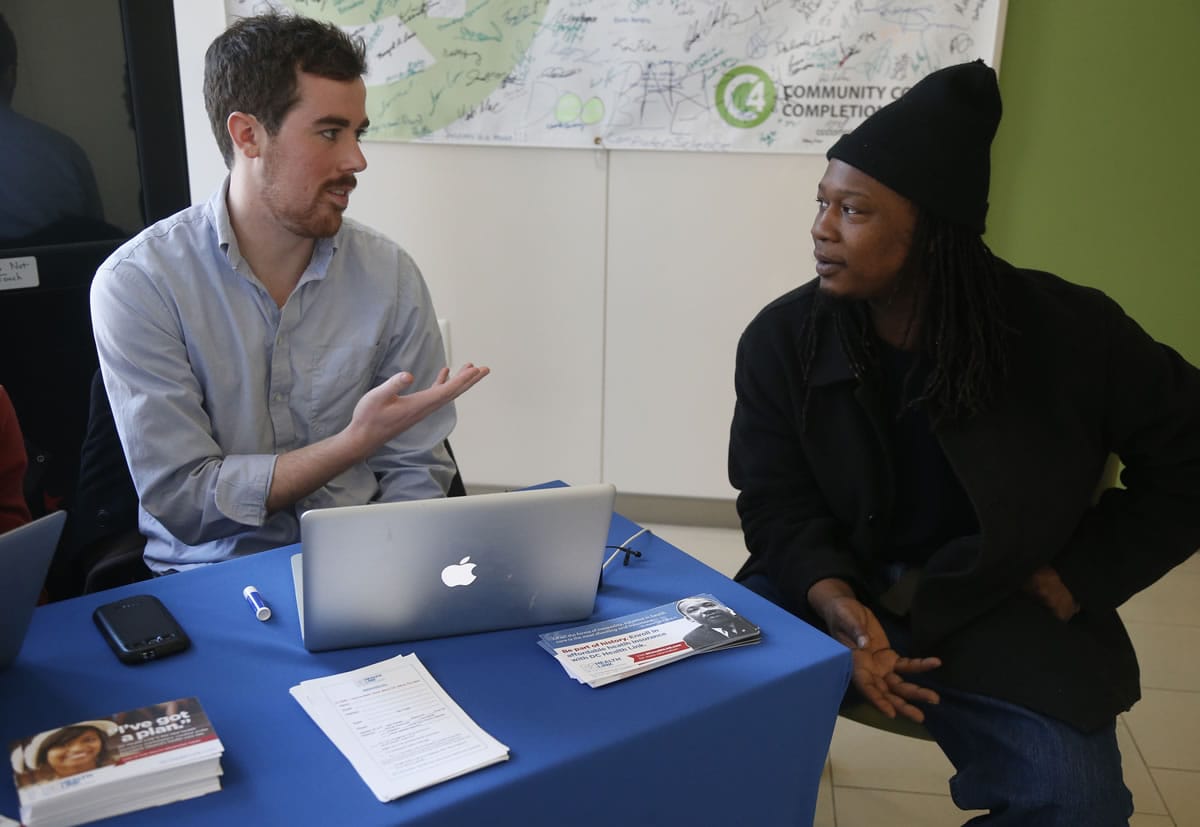 David Bransfield, a state outreach coordinator for Young Invincibles, a group which supports President Barack Obama's health care law, talks with student Philippe Komongnan, 27, who is in the process of signing up for health care, at the University of the District of Columbia in Washington on Jan. 30.