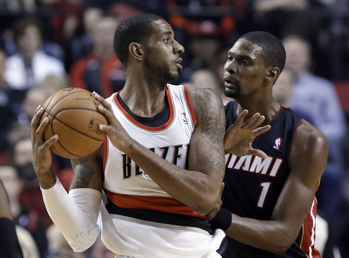 Portland's LaMarcus Aldridge, left, looks to pass as Miami's Chris Bosh defends during the first half Saturday. Aldridge had 22 points and seven rebounds in the game.