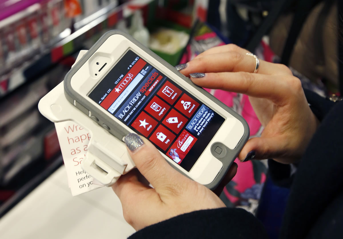 Tashalee Rodriguez, of Boston, uses a smartphone app while shopping at Macy&#039;s in downtown Boston.