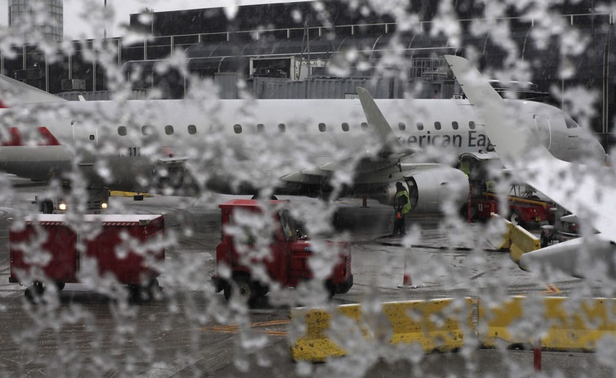A window on an American Eagle plane is covered with snow Sunday before it is de-iced at O'Hare International Airport in Chicago.