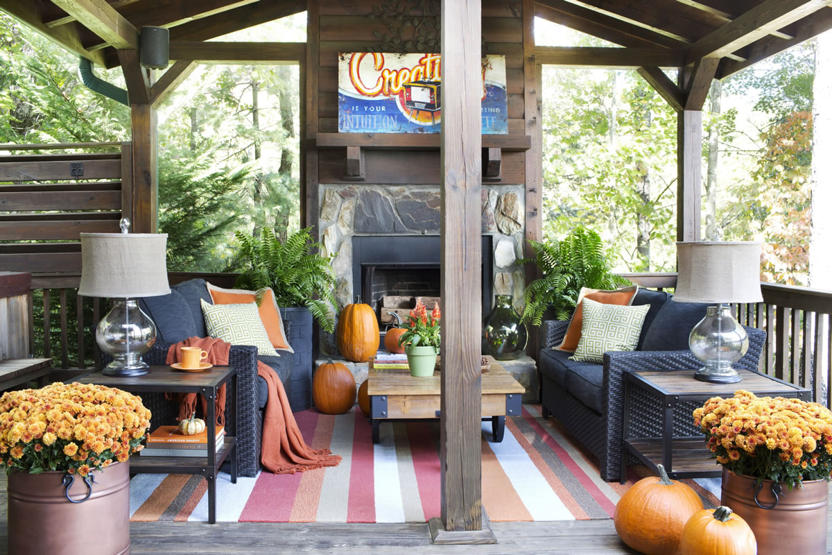 To ensure the outdoor living space of his mountain house stays warm and welcoming during the colder months, designer Brian Patrick Flynn chose woven blend upholstery for his seating, a wool and acrylic blend indoor-outdoor area rug, and throw pillows and blankets to keep guests feeling cozy.