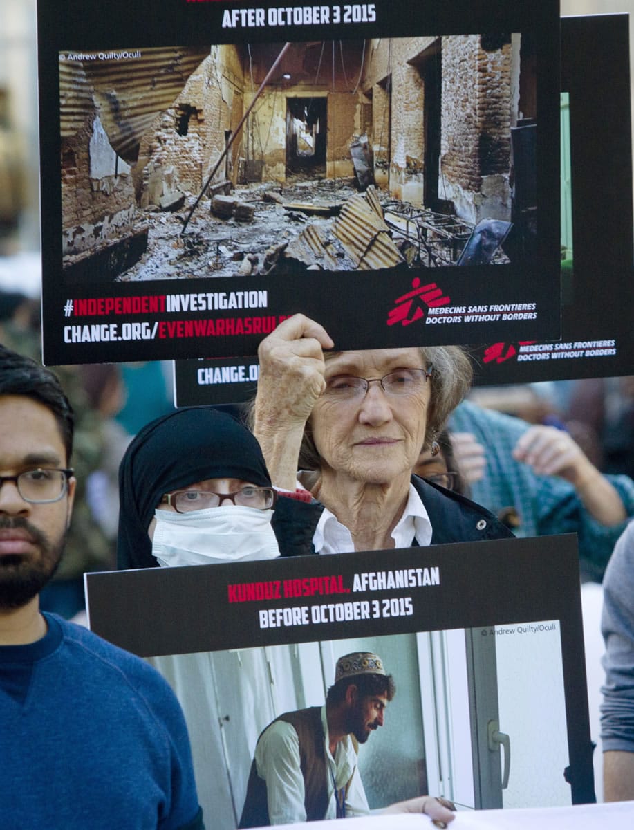 Supporters of Doctors Without Borders hold before-and-after images during a rally Tuesday in New York marking the one-month anniversary of a U.S. military strike on its trauma center in Afghanistan.