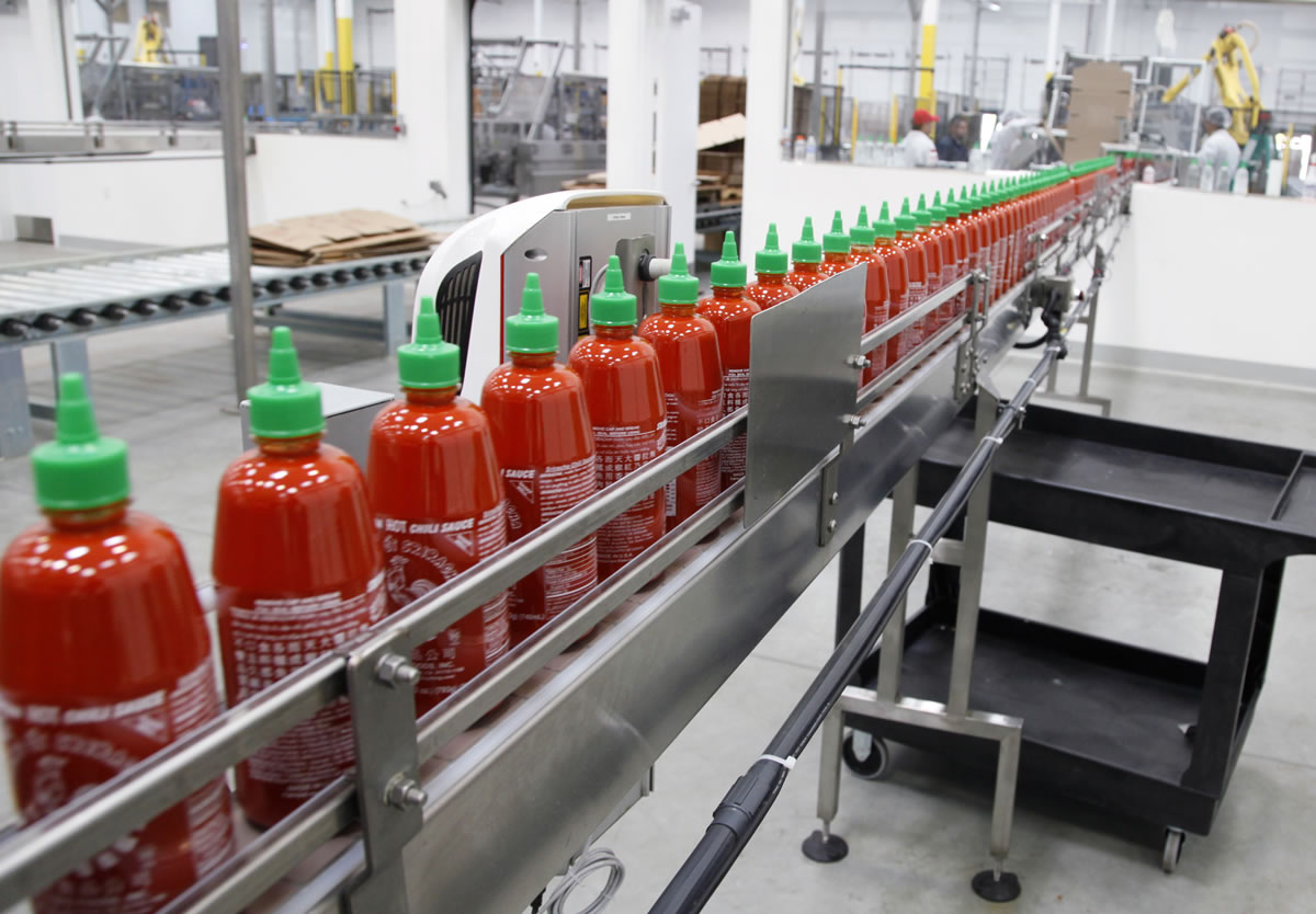 Sriracha chili sauce moves along a production line during at the Huy Fong Foods factory in Irwindale, Calif., on Tuesday.