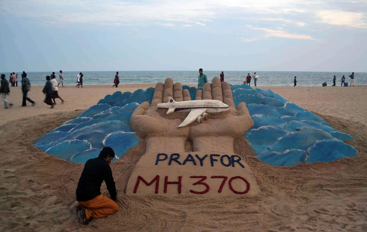 Sand artist Sudarshan Pattnaik creates a sculpture depicting the missing Malaysian Airlines aircraft on the beach in Puri, India, on Wednesday.