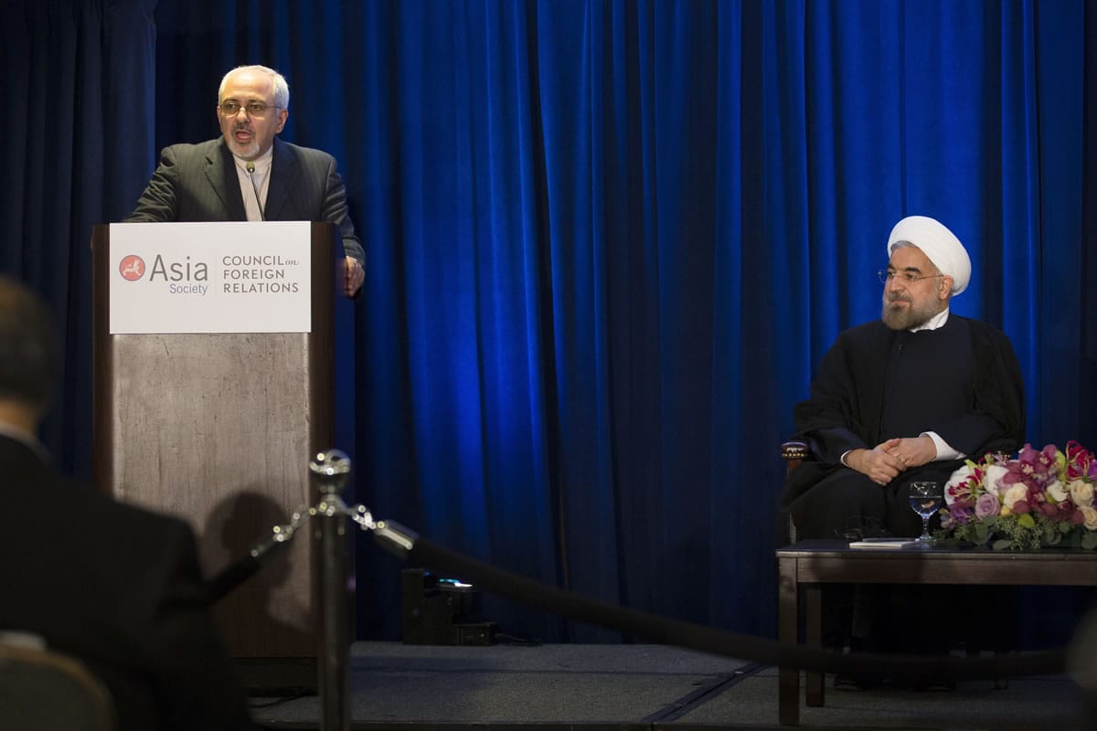 Iranian President Hassan Rouhani, right, listens as Iranian Foreign Minister Mohammad Javad Zarif, left, updates the audience on the results of his bilateral meeting with U.S.