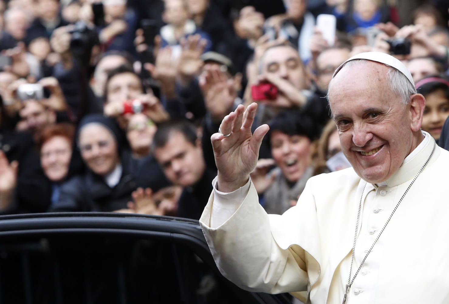 Pope Francis waves as he leaves Rome's Jesus' Church to celebrate a mass with the Jesuits, on the occasion of the order's titular feast Friday.
