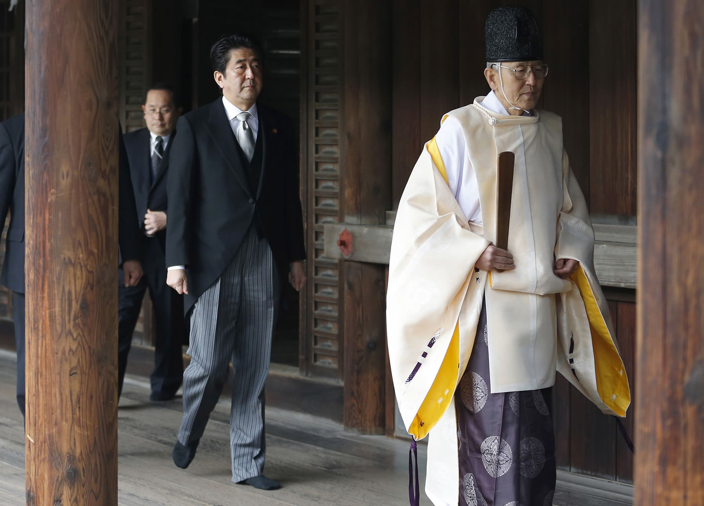 Japanese Prime Minister Shinzo Abe, second from right, follows a Shinto priest to pay respect for the war dead at Yasukuni Shrine in Tokyo on Thursday.