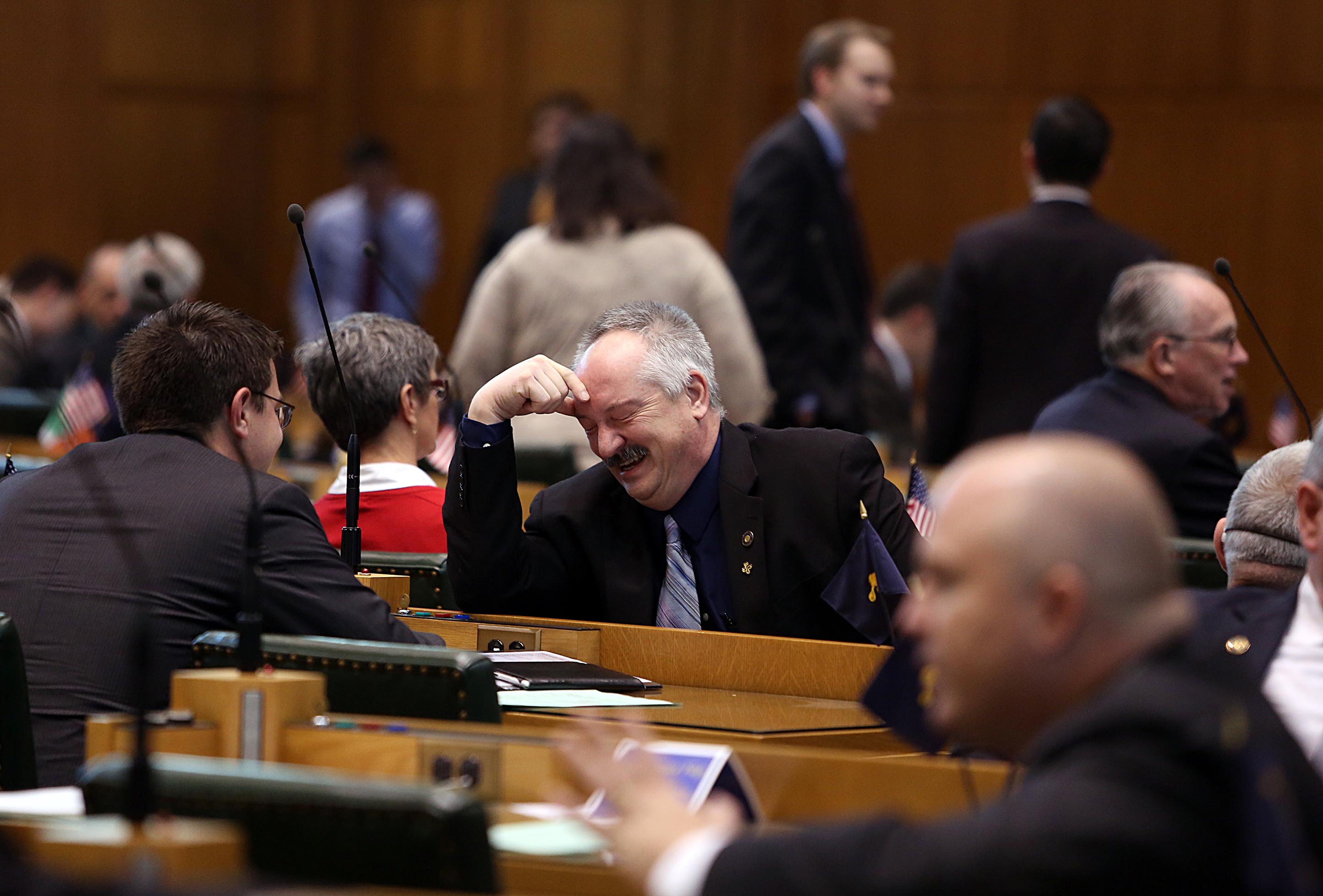 Rep. Chris Gorsek D-Troutdale, center, laughs with Rep. Brent Barton D-Oregon City, left, as the Oregon House convenes for the 2014 session Monday.