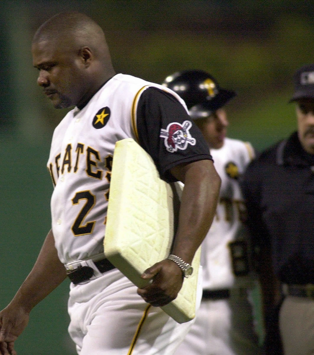 Pittsburgh Pirates manager Lloyd McClendon walks off the field carrying first base after being tossed from the game against the Milwaukee Brewers for arguing a call at first with umpire Rick Reed in this June 26, 2001 photo, in Pittsburgh. (AP Photo/Gene J.