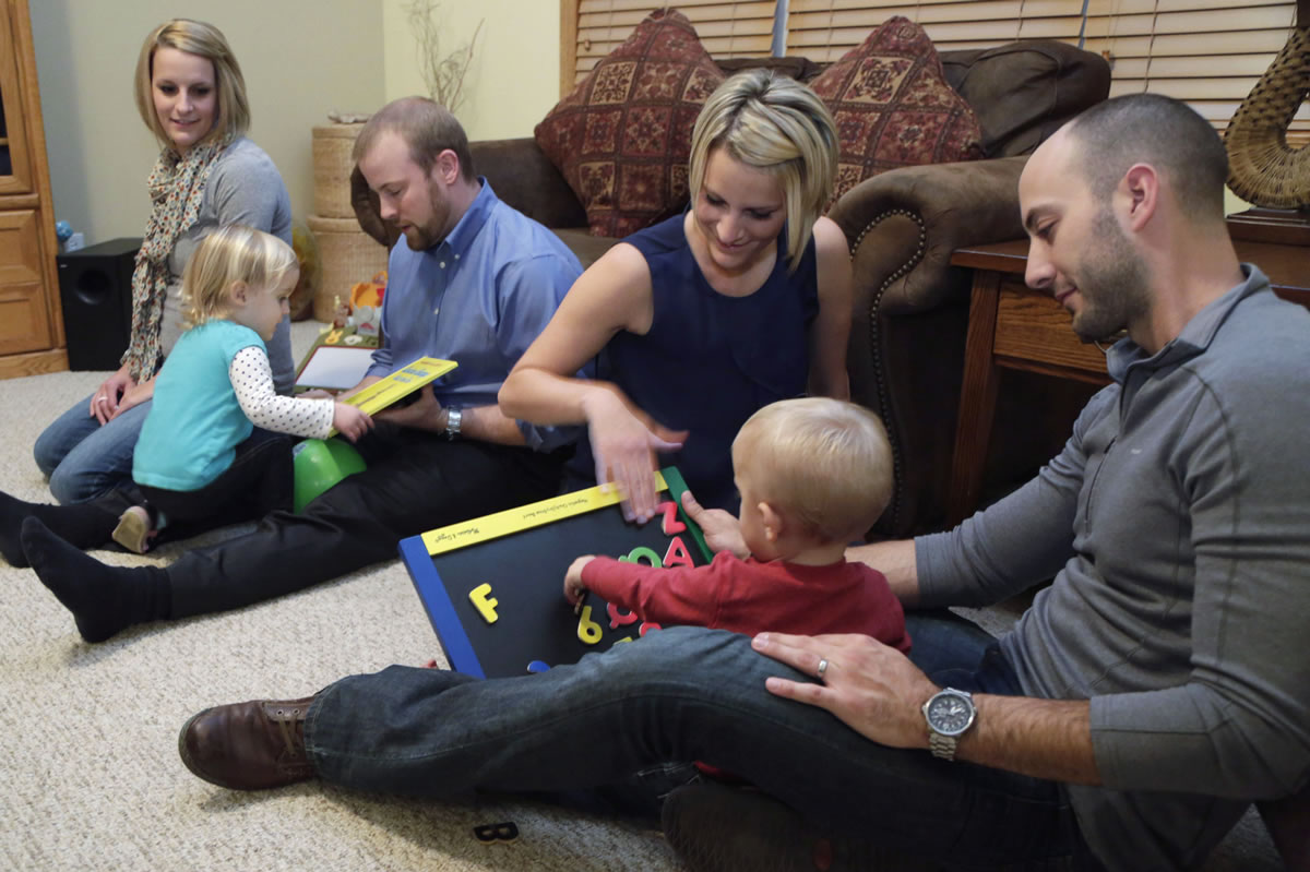 Kristen Maurer, her husband, Richard, and daughter Finley, at left, and Kristen's identical twin sister, Kelly McCarthy, her husband, Robert, and their son, Grey, at Kelly's mother-in-law's house in Beecher, Ill.