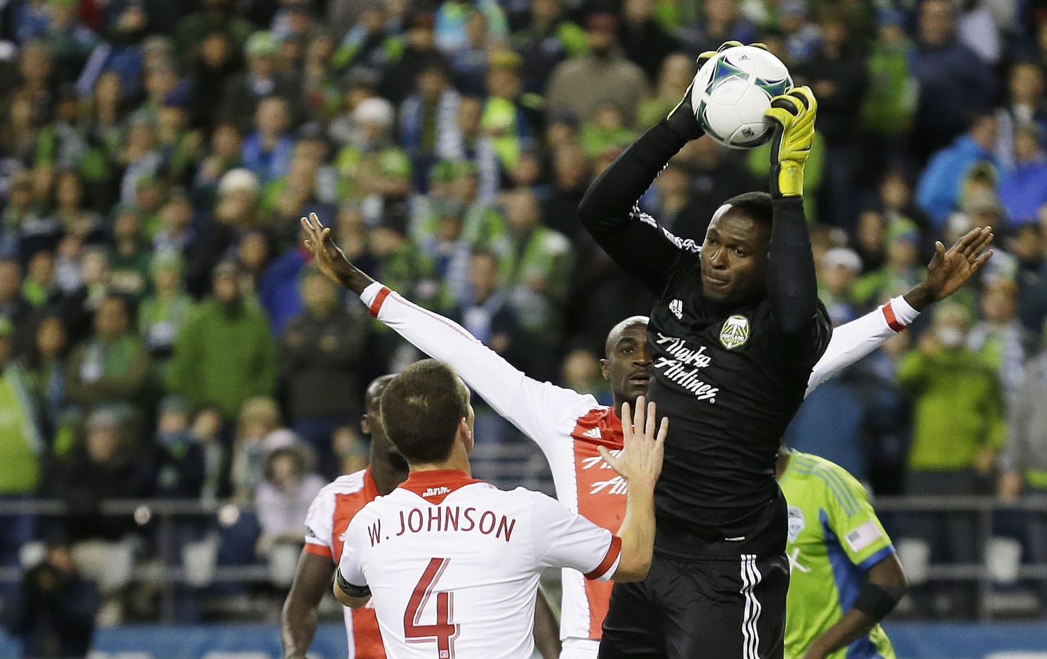 Portland Timbers goalkeeper Donovan Ricketts, right, pulls down the ball in the second half of the first game of the Western Conference semifinals in the MLS Cup soccer playoffs on Saturday, Nov. 2, 2013, in Seattle. The Timbers defeated the Sounders 2-1 in the first of two aggregate-score matches. (AP Photo/Ted S.