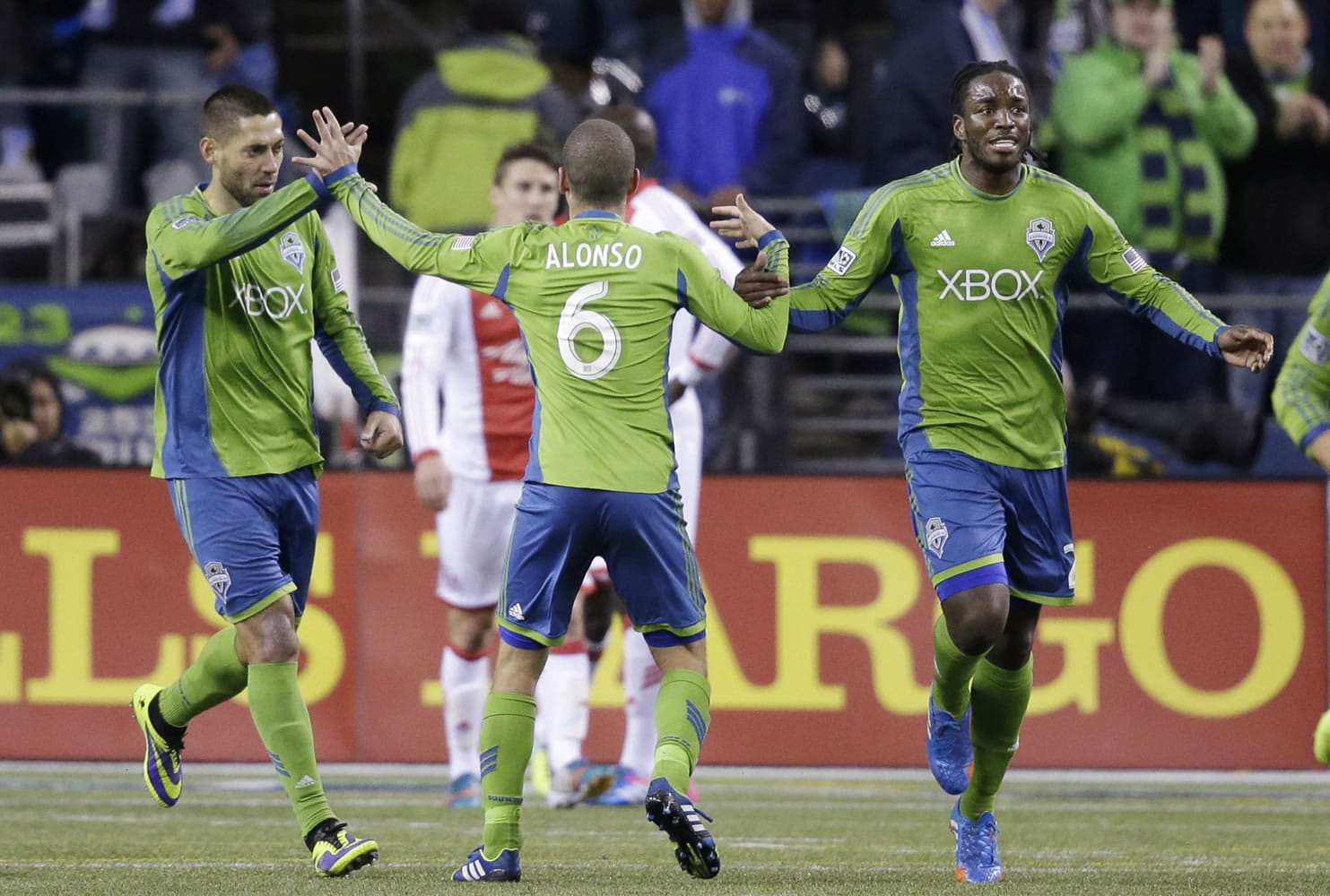 Seattle Sounders' Osvaldo Alonso (6) celebrates scoring with Clint Dempsey, left, and Shalrie Joseph against the Portland Timbers in the second half of the first game of the Western Conference semifinals in the MLS Cup soccer playoffs on Saturday, Nov. 2, 2013, in Seattle. The Timbers won 2-1 in the first of the two-game aggregate playoff series.