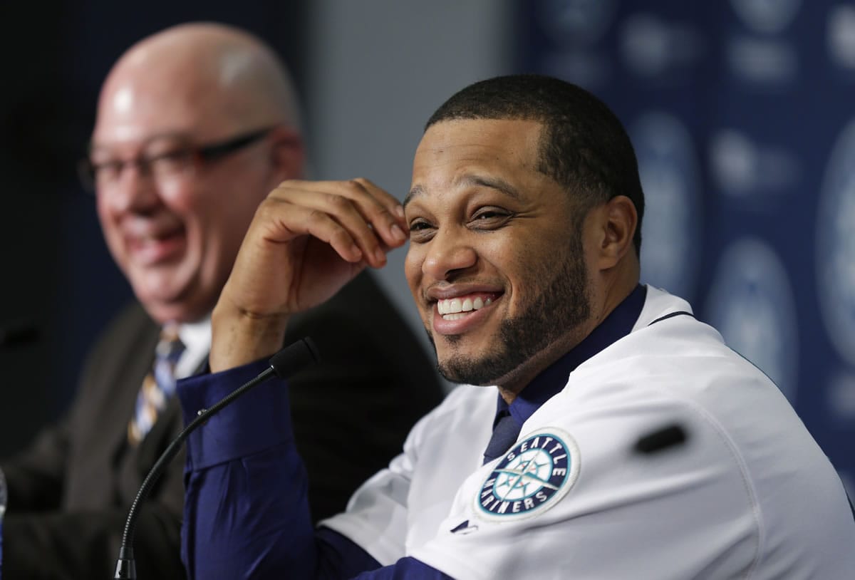 Robinson Cano, right, smiles as he sits next to Seattle Mariners general manager Jack Zduriencik, left, after Cano was introduced as the newest member of the Seattle Mariners on Thursday.