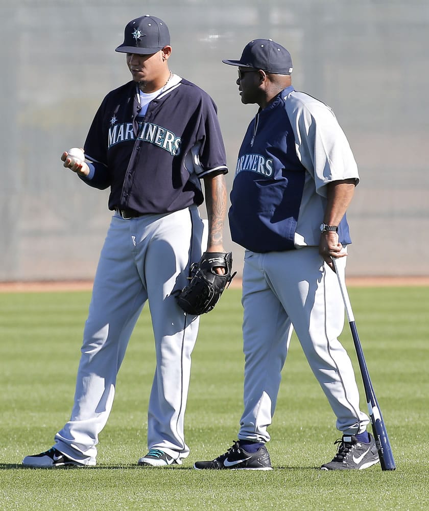 Seattle Mariners pitcher Felix Hernandez talks with manager Lloyd McClendon during their first spring training baseball practice Thursday at Peoria, Ariz.