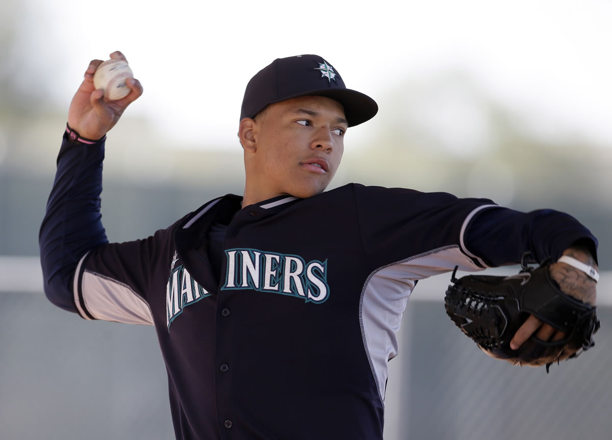 Seattle pitcher Taijuan Walker throws in a bullpen session during spring training baseball practice, Thursday in Peoria, Ariz.