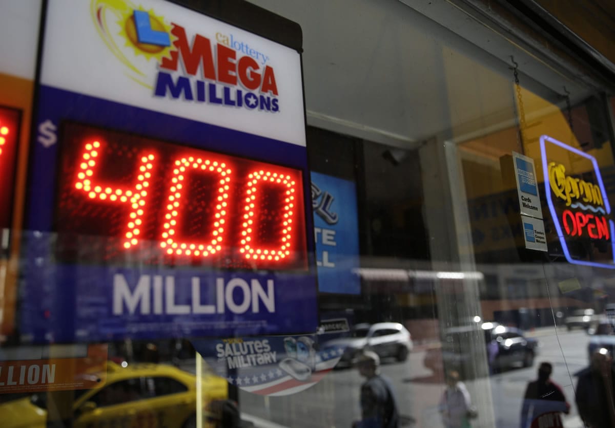 A sign displays an earlier current Mega Millions jackpot at a Financial District liquor store in San Francisco on Dec.