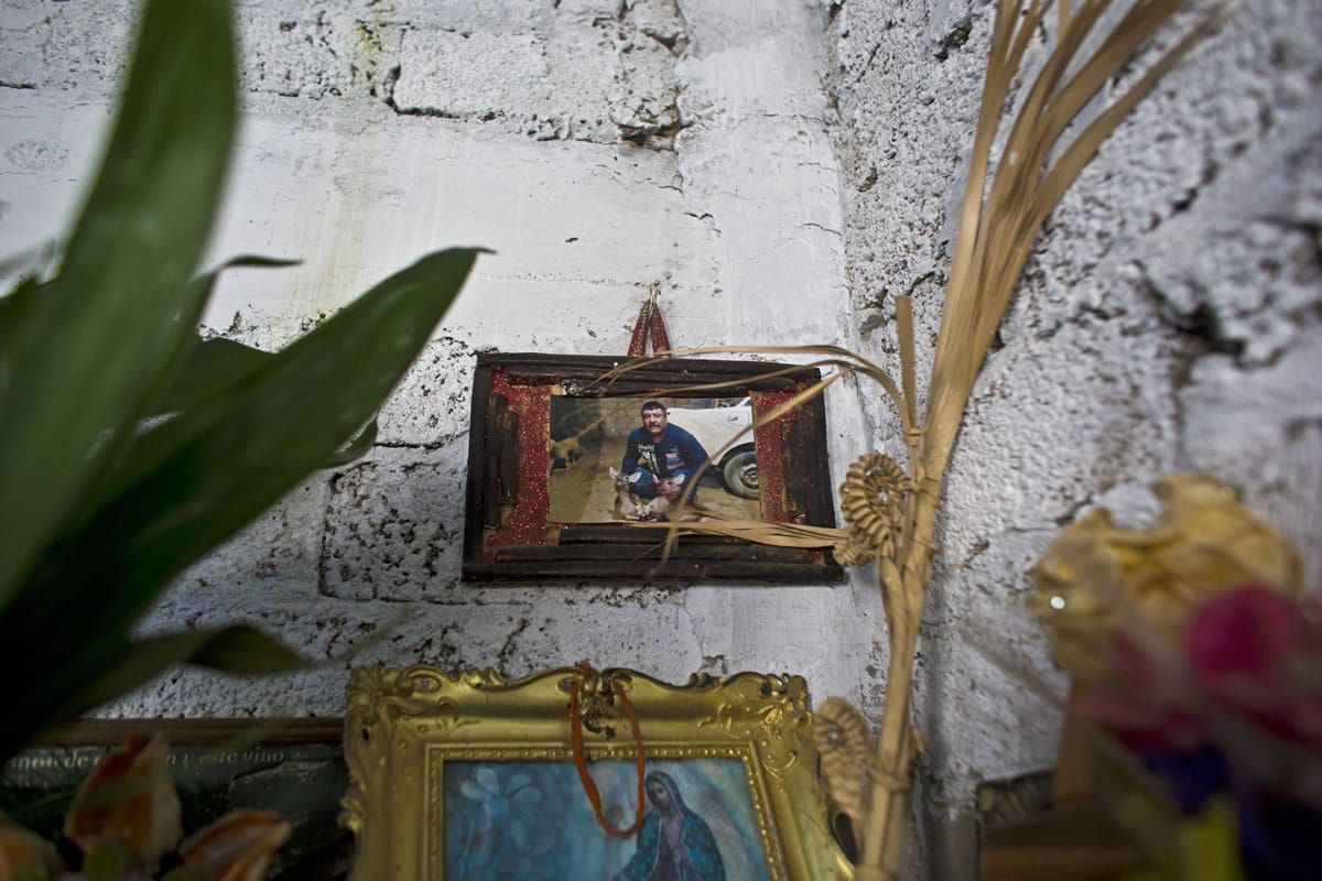A framed snapshot of Carlos Sanchez hangs over a makeshift altar in his widow&#039;s home in Teloloapan, Mexico.