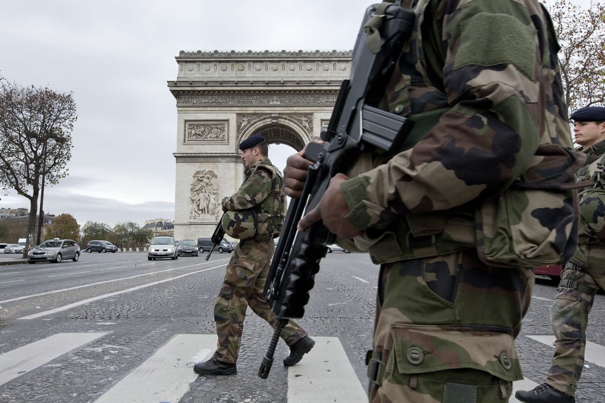 French soldiers cross the Champs Elysees avenue passing the Arc de Triomphe in Paris on Monday.