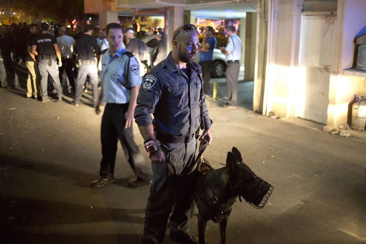 Israeli police officers secure the stabbing attack site in Netanya, Israel, on Monday. A Palestinian stabbed and wounded a 70-year-old man in northern Israel before being shot by officers, police said Monday just hours after another Palestinian knifed several people, including an 80-year-old woman, in a stabbing spree near Tel Aviv, the latest attacks in more than a month of violence.