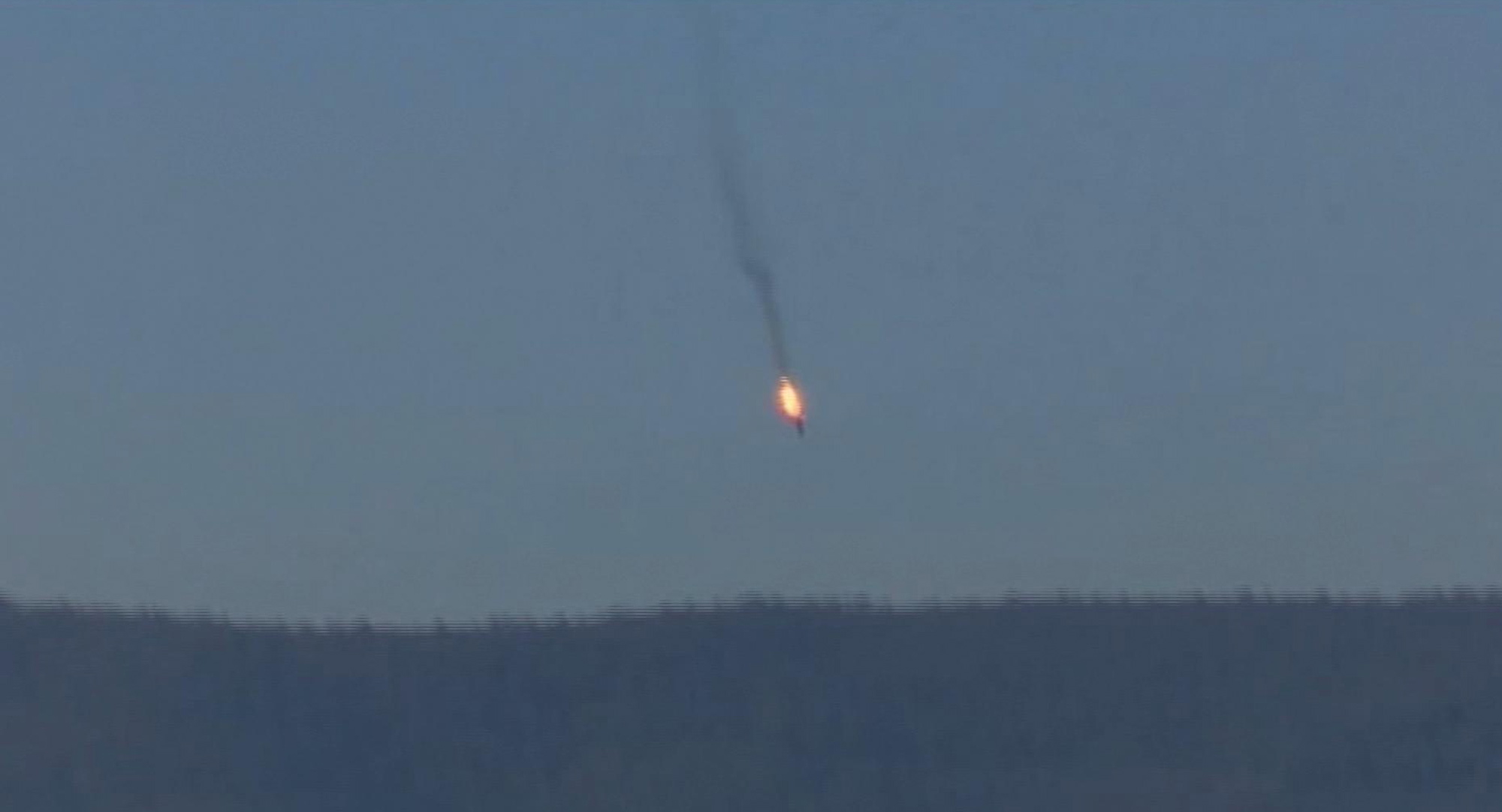 A Russian warplane on fire before crashing on a hill as seen from Hatay province, Turkey, on Tuesday. Turkey shot down the Russian warplane Tuesday, claiming it had violated Turkish airspace and ignored repeated warnings. Russia denied that the plane crossed the Syrian border into Turkish skies.