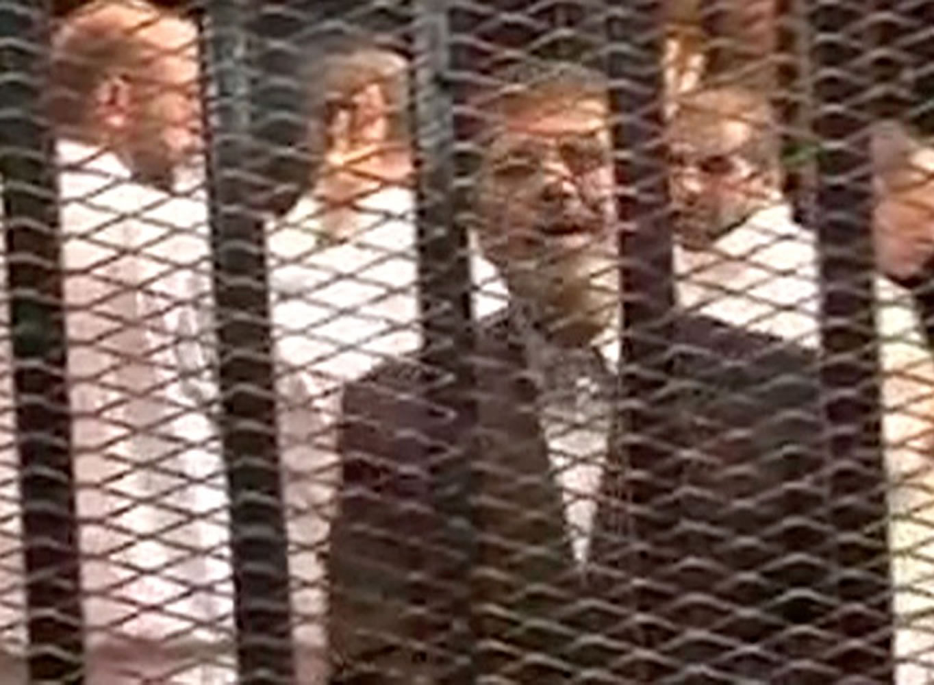 This image made from video provided by Egypt's Interior Ministry shows ousted President Mohammed Morsi, right, speaking from the defendant's cage as he stands with co-defendants in a makeshift courtroom during a trial hearing in Cairo, Egypt, on Monday.