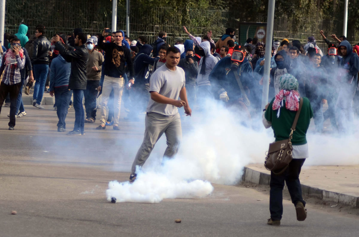 Supporters of  ousted Islamist President Mohammed Morsi try to avoid tear gas as security forces disperse a gathering Thursday near Cairo University in Giza, Egypt.