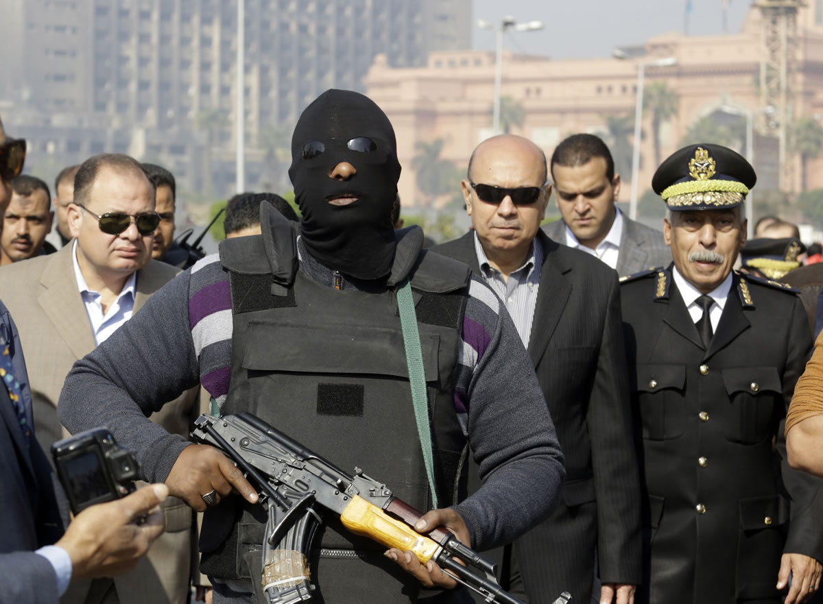 An Egyptian masked policeman guards officials Jan. 25 in Cairo.