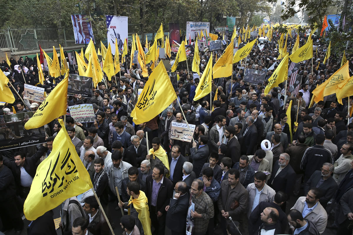 Iranian protesters hold flags during an annual anti-American demonstration in Tehran, Iran, on Monday. Tens of thousands of demonstrators packed the streets Monday outside the former U.S.