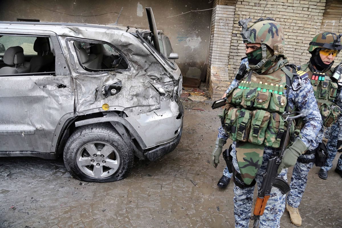 Security forces inspect the site of a car bomb attack in Baghdad's Karrada neighborhood, Iraq, on Wednesday.