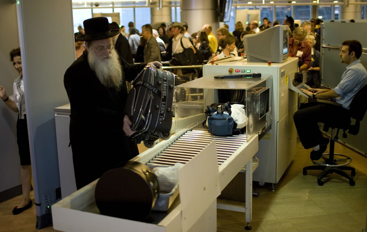 Passengers have their hand luggage screened by security personnel inside the Ben-Gurion airport terminal near Tel Aviv, Israel, in 2010.