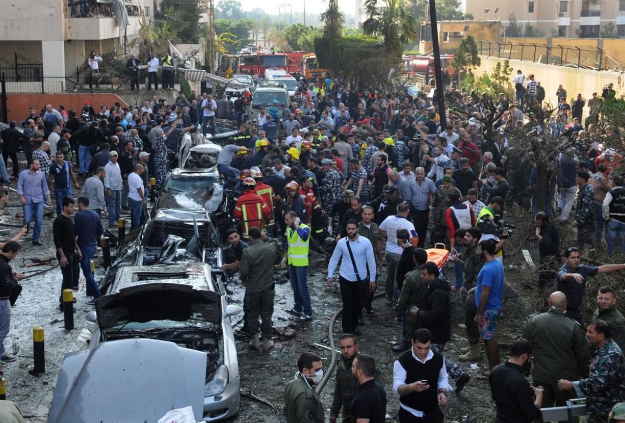 Lebanese citizens and security forces gather near the entrance of the Iranian embassy, background, where two explosions have struck in Beirut, Lebanon, on Tuesday .