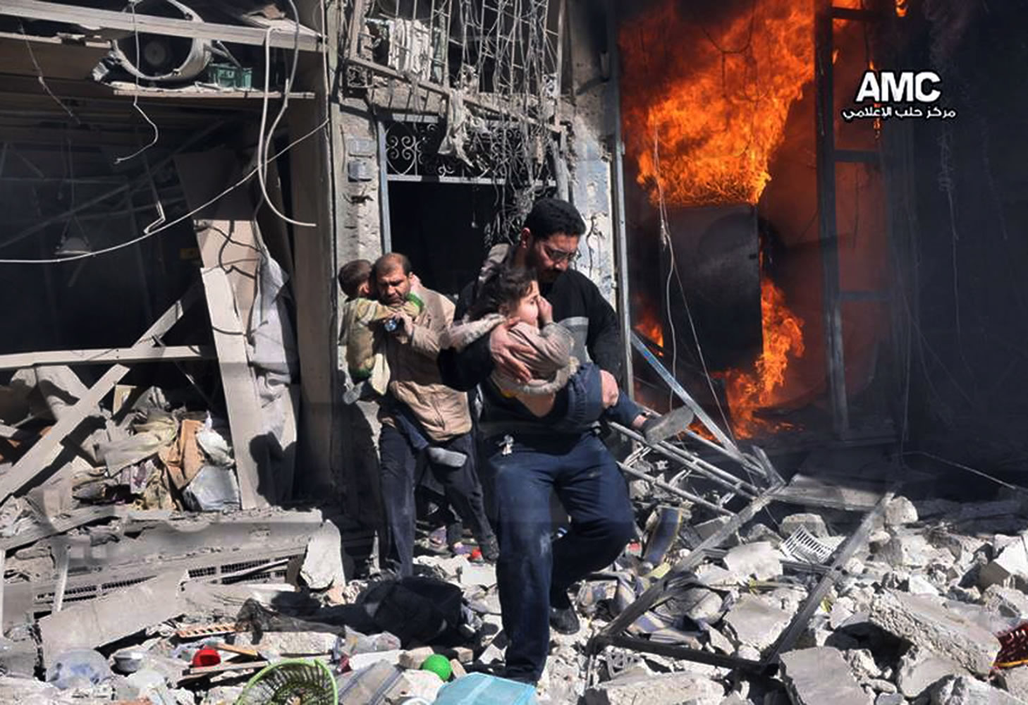 Syrian men help survivors out of a destroyed building after a Syrian forces warplane's attack Saturday in the northern city of Aleppo, Syria. Syrian military aircraft dropped barrel bombs on rebel-held areas.