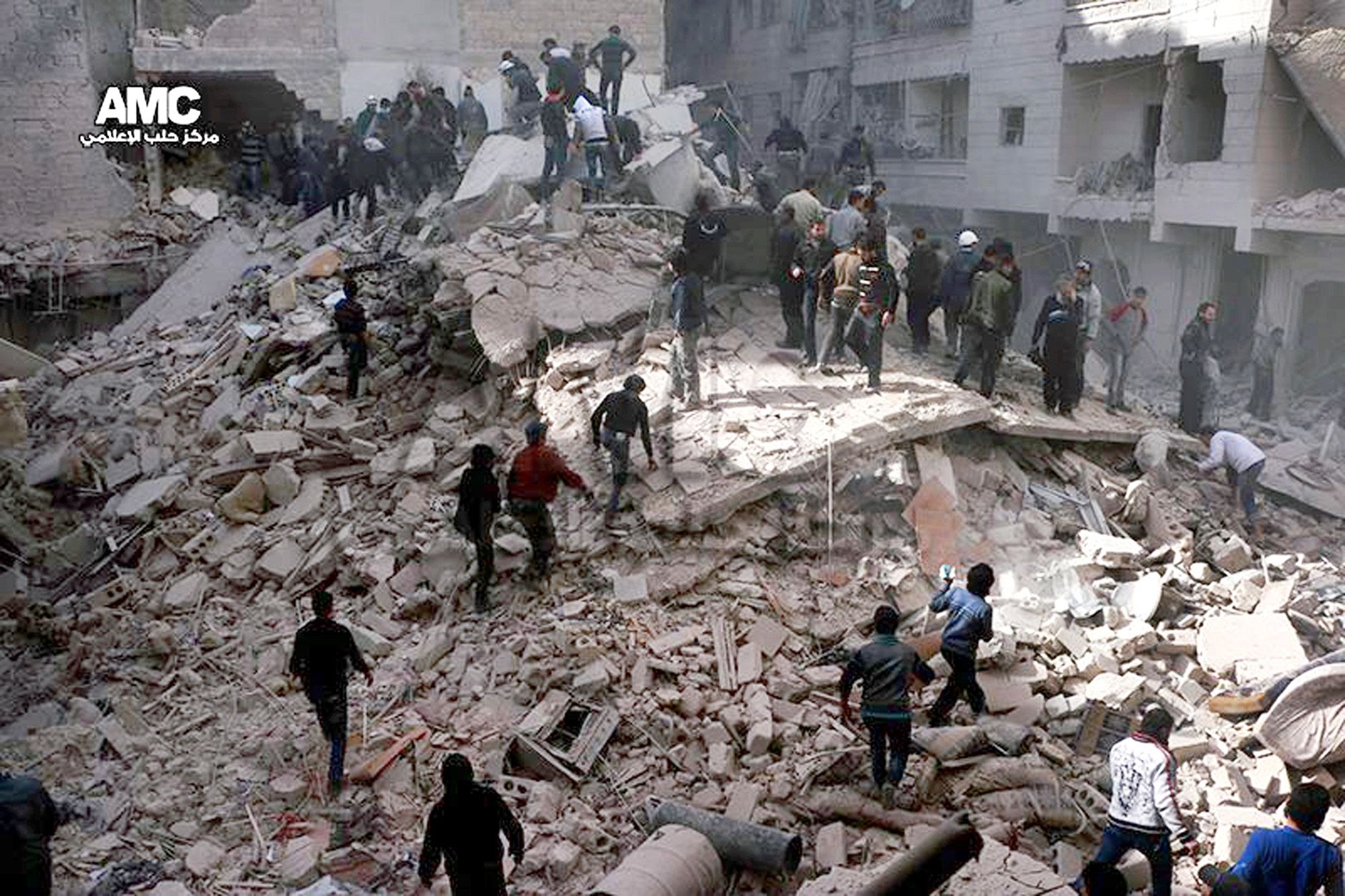 This photo taken Wednesday and provided by the anti-government activist group Aleppo Media Center shows people inspecting the rubble of destroyed buildings following a Syrian government airstrike in Aleppo, Syria.