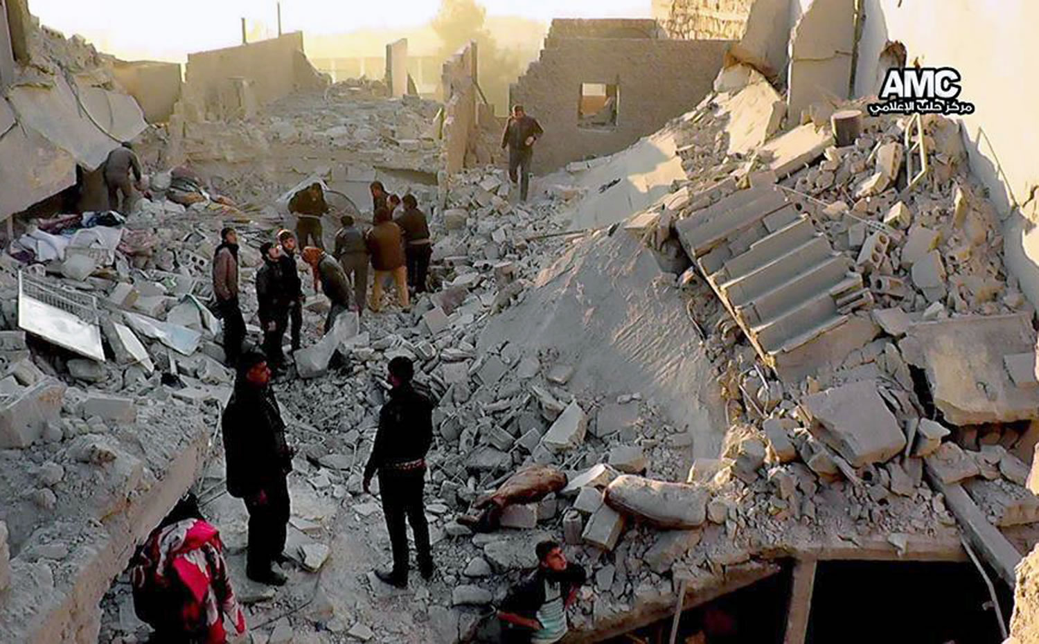 Syrians inspect the rubble of destroyed buildings following a Syrian government airstrike in Aleppo, Syria.