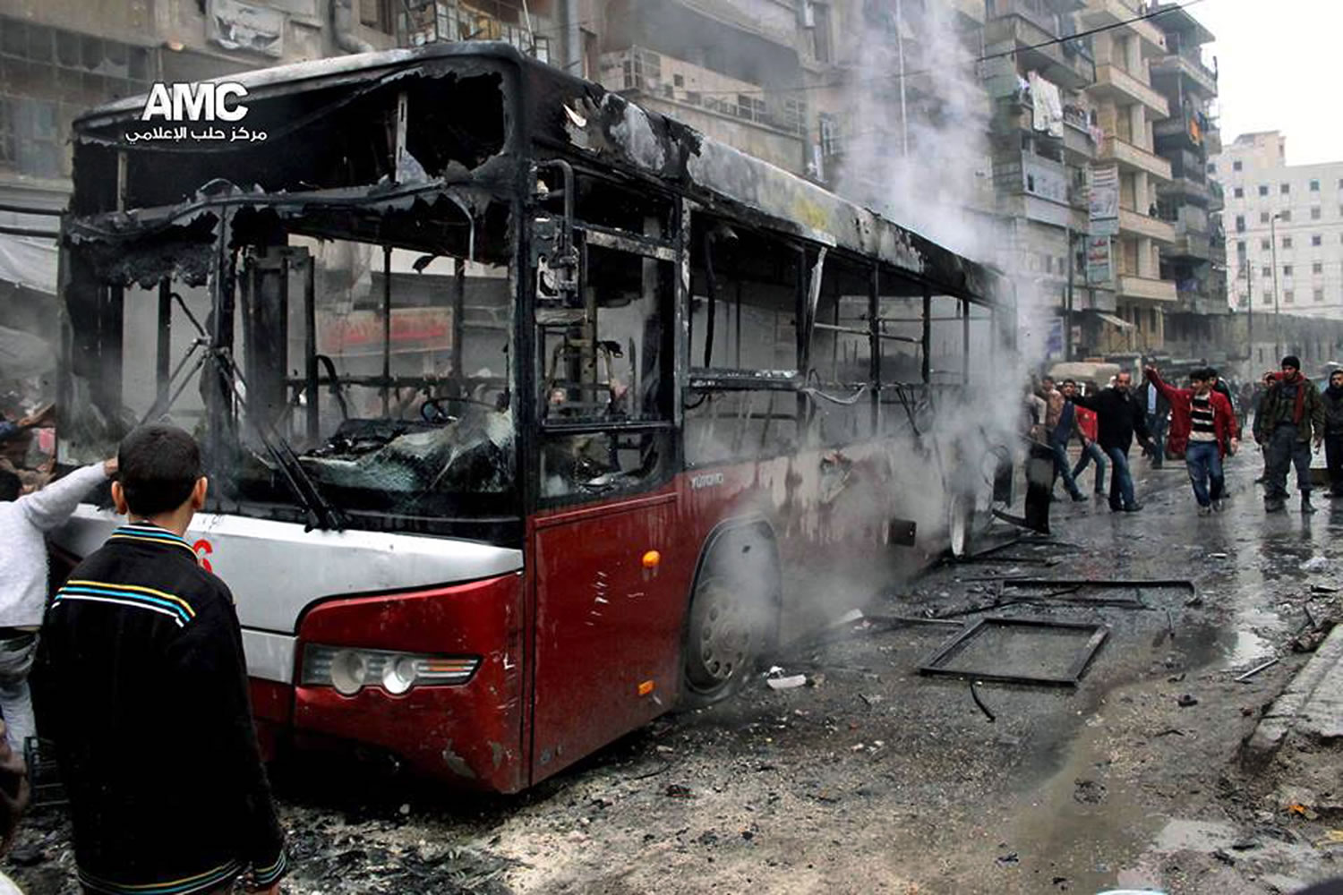 Syrians inspect a burnt bus after a missile fired by Syrian government aircraft hit the vehicle Tuesday in the rebel-held neighborhood of al-Bab in Aleppo, Syria.