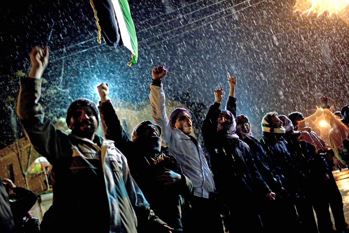 Free Syrian Army supporters chant anti government slogans under snowfall on the outskirts of Idlib , north Syria in February of 2012.