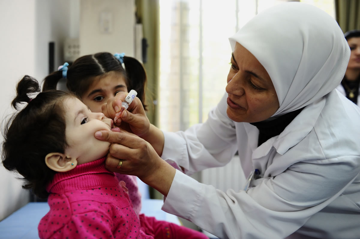 A health worker administers polio vaccine to a child on Oct.
