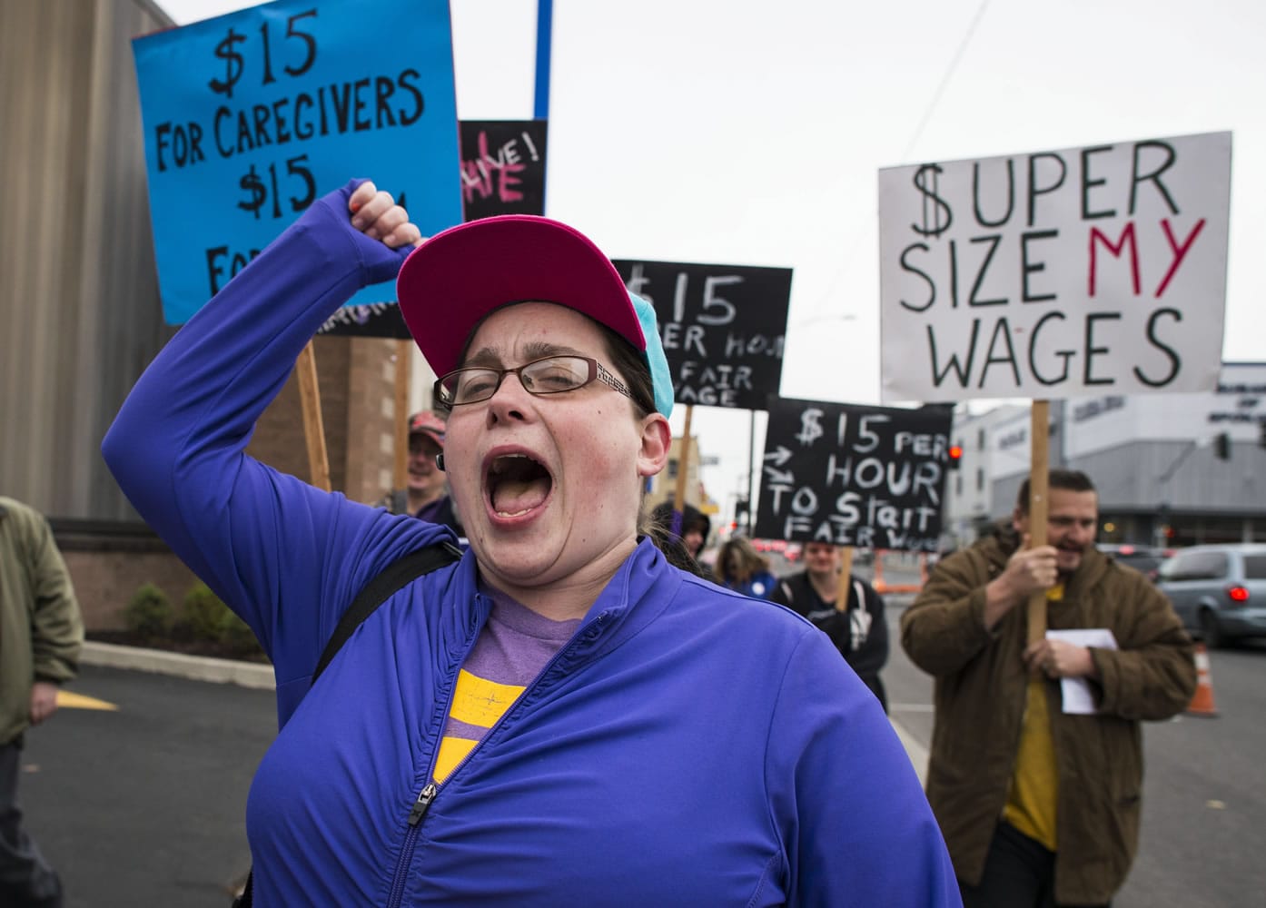 Jan Devery marches with other minimum wage workers along Third Avenue in Spokane where many fast food businesses are located Tuesday. They are supporting the  &quot;It&#039;s Our Time&quot; initiative pushing for higher minimum wages in the state. Rallies were also held in Seattle, Yakima and Olympia.