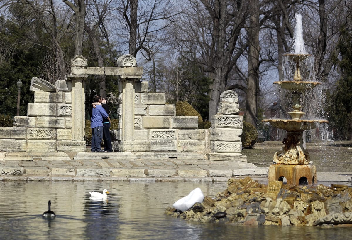 Jonathan Tidball, left, and his girlfriend Jenna Ferguson, both of O'Fallon, Ill., enjoy spring-like weather as they stand near a small pond in Tower Grove Park on Tuesday in St.