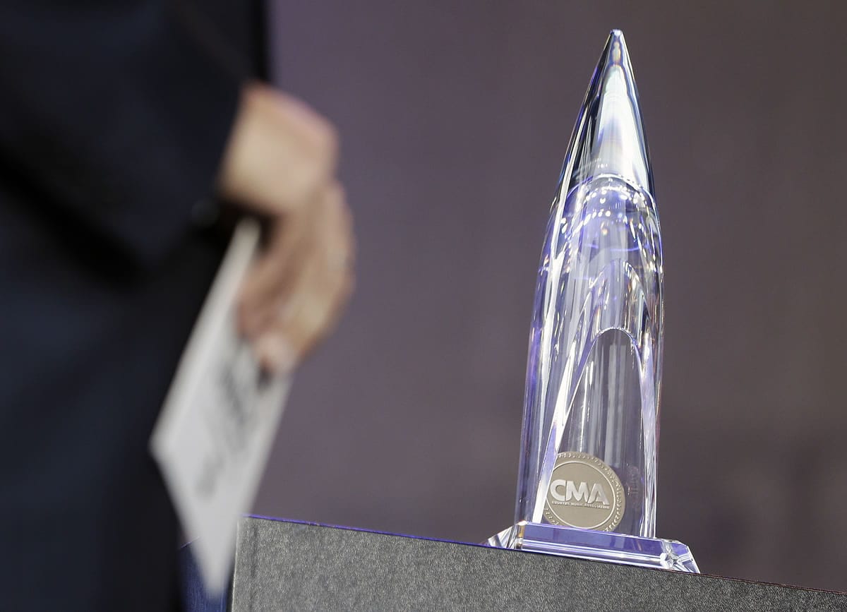 A Country Music Association Award is displayed on a table as an attendant holds the envelope holding the name of the winner of the music video of the year award, announced during a broadcast of the TV show &quot;Good Morning America&quot;, Wednesday, Nov. 6, 2013, in Nashville, Tenn. The video for the song &quot;Highway Don't Care,&quot; by Tim McGraw and Taylor Swift, won the award. The CMA Awards will be held Wednesday night.