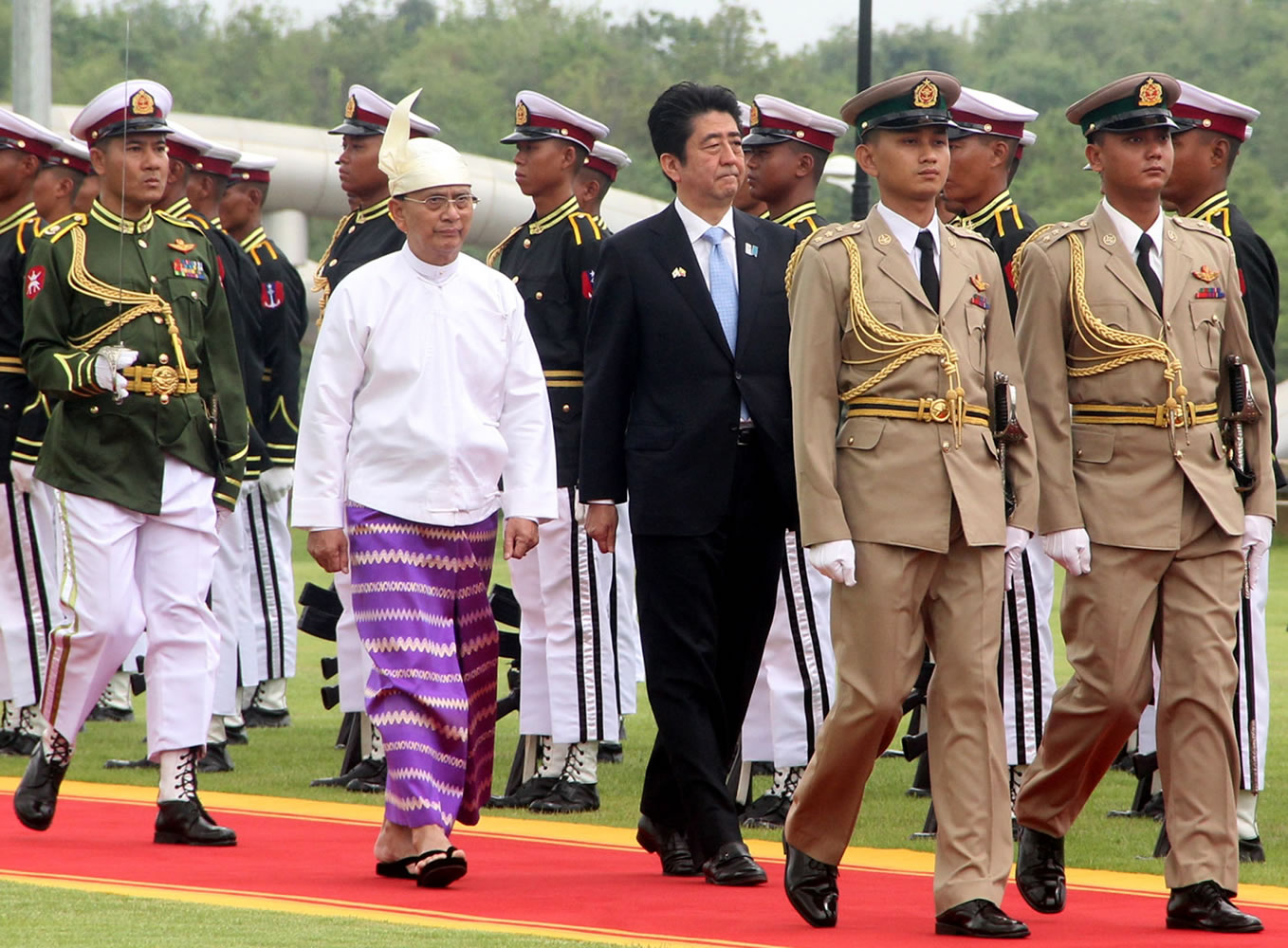 Japanese Prime Minister Shinzo Abe, center right, and Myanmar President Thein Sein, center left, inspect the honor guard at Presidential Palace on Sunday in Naypyitaw, Myanmar.