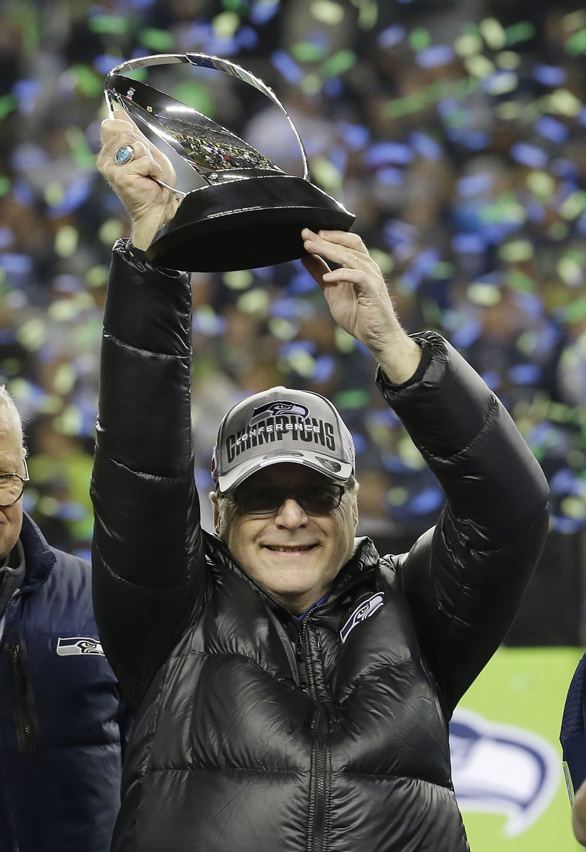 Seattle Seahawks owner Paul Allen holds up the George Halas Trophy on Jan. 19 after the NFL football NFC Championship game against the San Francisco 49ers.