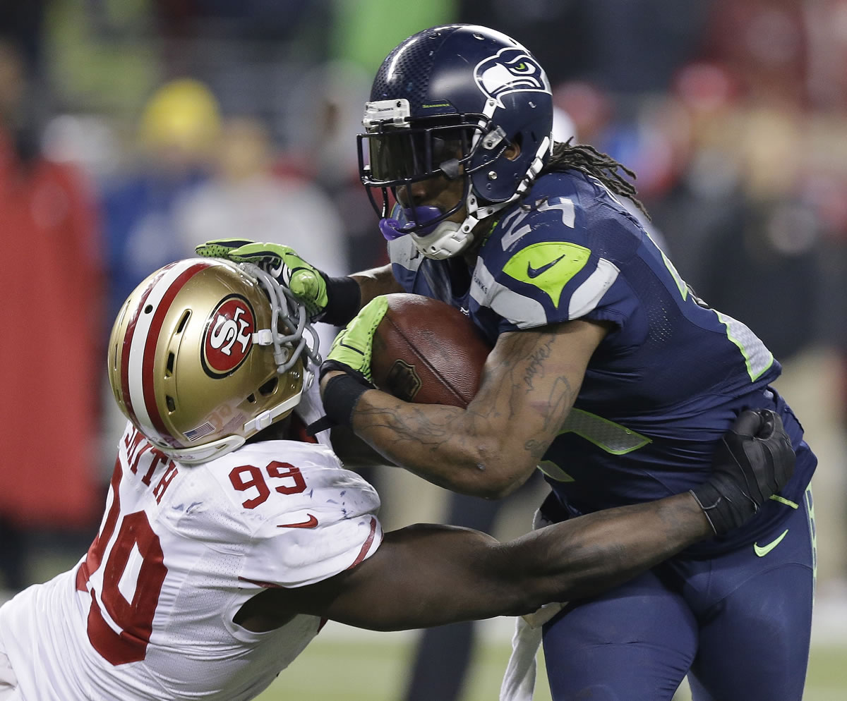 Seattle Seahawks' Marshawn Lynch tries to run past San Francisco 49ers' Aldon Smith during the second half of the NFL football NFC Championship game Sunday, Jan. 19, 2014, in Seattle.