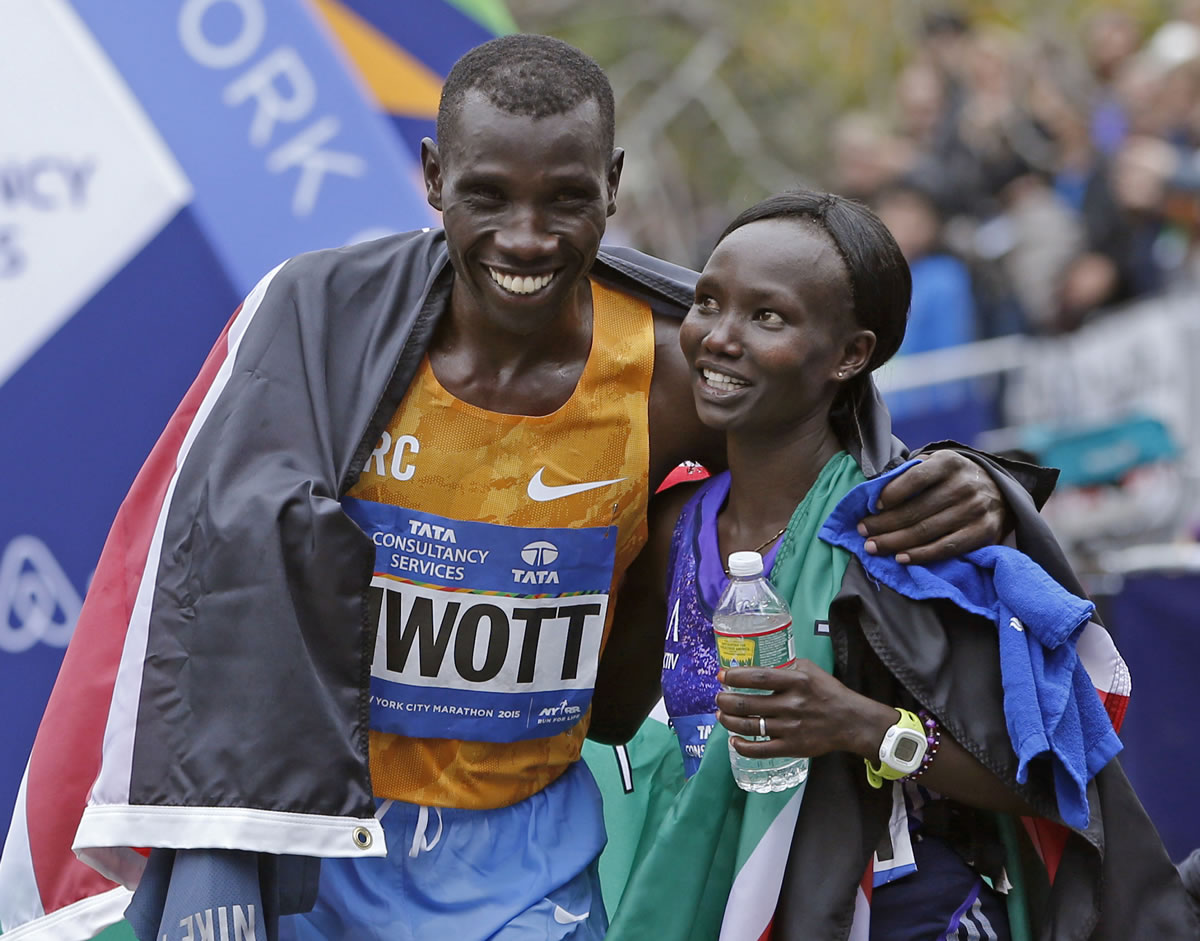 Kenya's Stanley Biwott, left, embraces fellow Kenyan Mary Keitany after the pair won the men's and women's professional women's athlete divisions in the the New York City marathon, Sunday, Nov. 1, 2015 in New York.