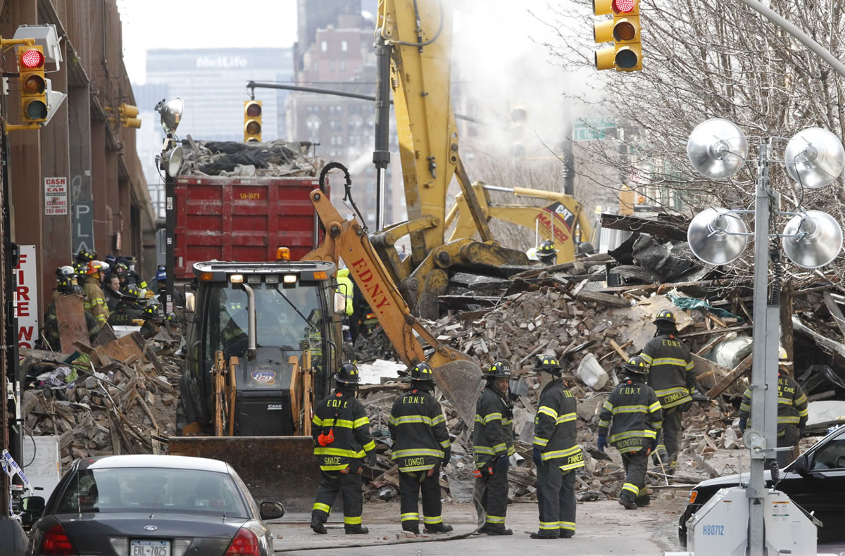 Firefighters continue to investigate and remove debris from an explosion Thursday in New York.