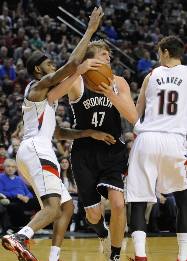 Brooklyn Nets' Andrei Kirilenko (47) drives against Portland Trail Blazers' Will Barton (5) and Victor Claver (18) during the first half Wednesday.